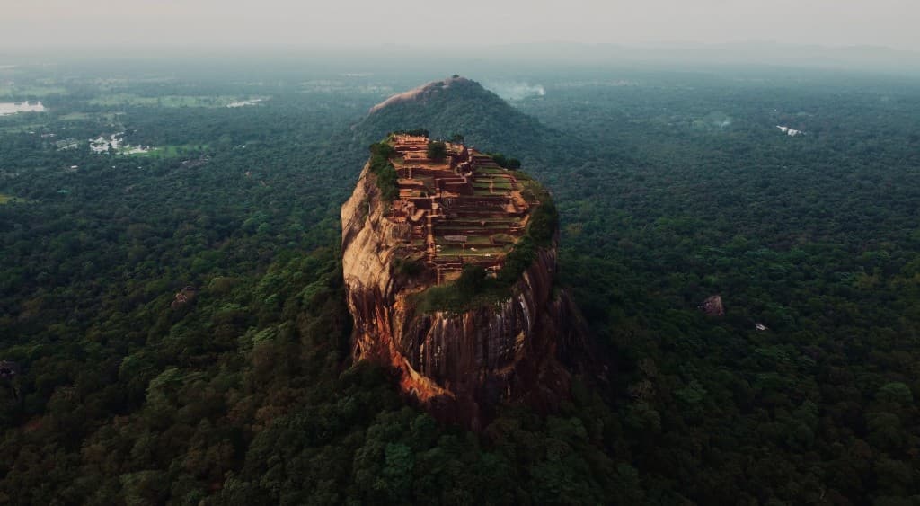 Aerial view of Sigiriya rock fortress rising from surrounding jungle